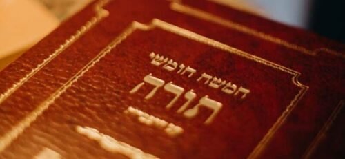 A close-up view of a Torah book with Hebrew text, symbolizing Jewish tradition and spirituality.